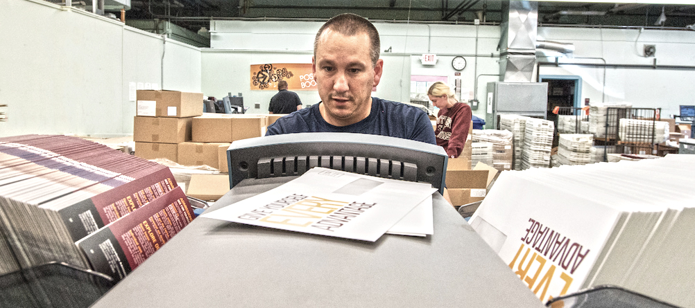 Person operating envelope stuffing machine